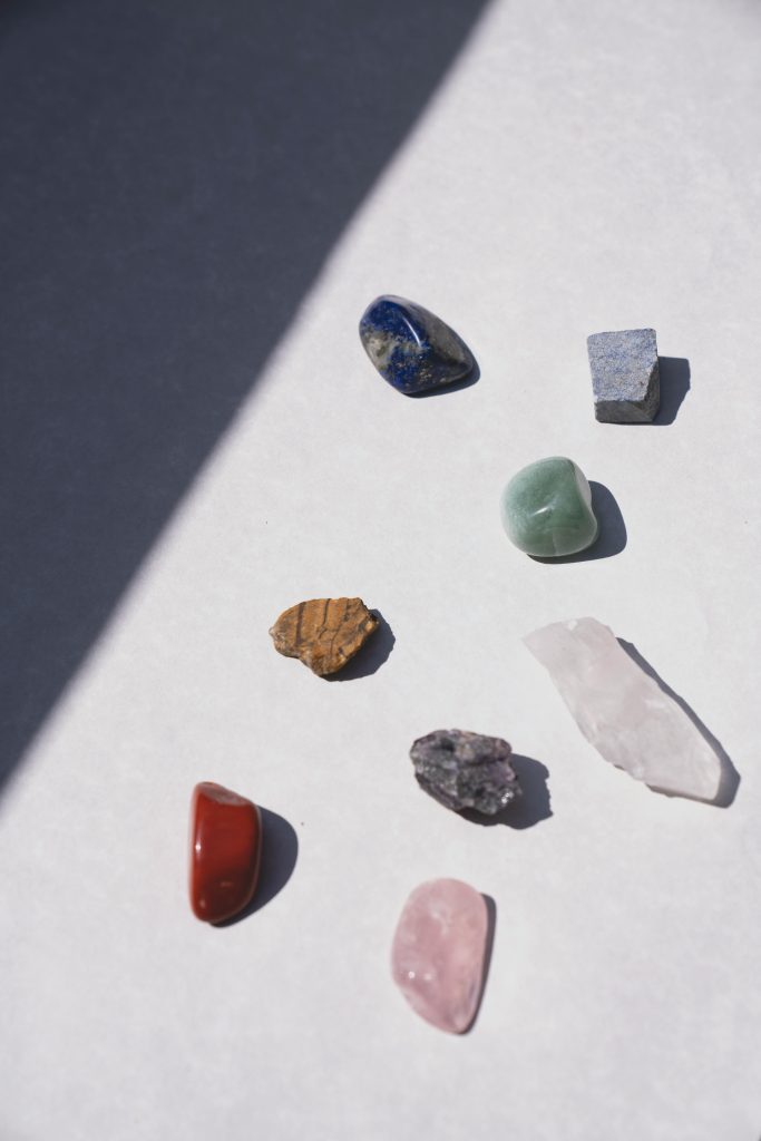 Assorted gemstones arranged in a flatlay with soft lighting, highlighting their crystalline beauty.